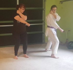 kitty and emma in a garage learning karate.