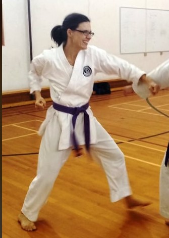woman in a karate gi in fighting stance.