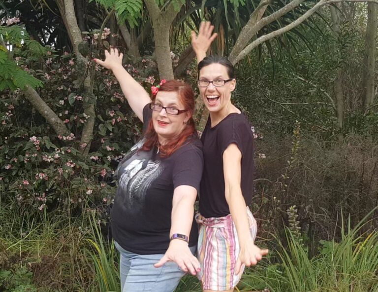 kitty fitton and emma kyriacou smiling with arms outstretched like aeroplanes.