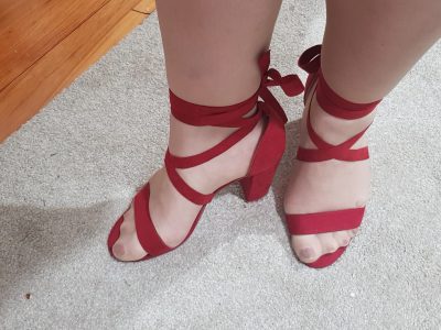 woman's feet in red strappy sandals.